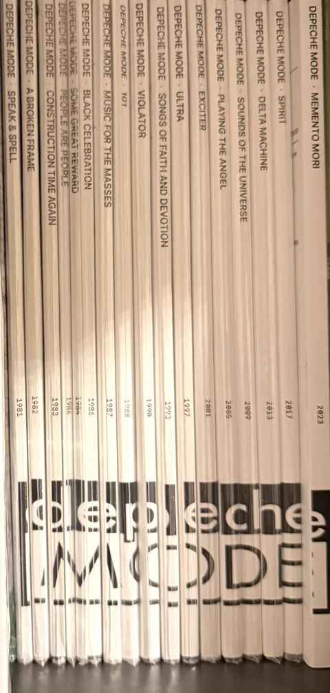 Records filed on a shelf, their printed OBI strips forming one image across the spines